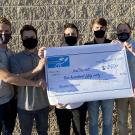 five males wearing masks holding large check for little bang season 1 winner